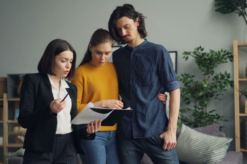 Home 15 A couple reviewing documents with a real estate agent indoor 1781629493